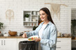 © Pixel-Shot - Young woman throwing organic food into trash bin in kitchen. Waste recycling concept