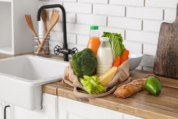 Wall Mural - Shopping bag with different fresh products near sink on counter in kitchen