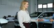 © m-art - The manager hands over the car keys to the buyer. They shake hands and smile. A stylish woman bought a car at a car dealership