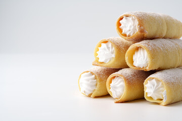 Wall Mural - Delicious cream-filled pastries stacked on a white surface ready to be enjoyed at a dessert table