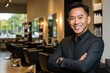 © BerkahStock - Smiling Asian man in a black suit standing in a hair salon.