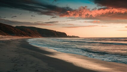 Aufkleber - Serene ocean shoreline at low tide, warm sunset hues of orange and blue reflecting on gentle waves, soft sandy beach in the foreground.