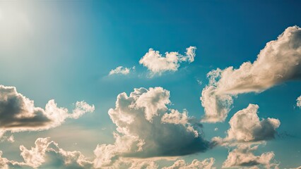 Poster - Bright blue sky filled with fluffy white clouds casting soft shadows under the sunlight creating a serene and tranquil atmosphere.