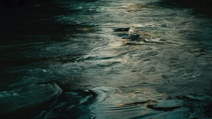 Poster - Rippling water surface of a dark river in shades of blue and green reflecting soft light with dynamic wave patterns across the image space