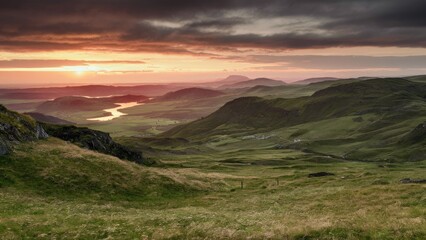 Poster - Serene landscape at sunset showcasing rolling green hills and a winding river beneath a dramatic sky with clouds in shades of orange and gray