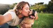 © peopleimages.com - Woman, kiss and selfie with dog on grass field for picture, memory or companion in nature. Female person, labrador or golden retriever with hug or affection for capture, support or care for pet