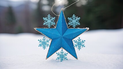 Poster - Blue star ornament surrounded by light blue snowflakes on snow with a blurred wintery background featuring evergreen trees.