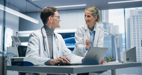 Aufkleber - Two Doctors in a.Hospital Office Analyze Patient Data on a Laptop, Discussing Diagnosis and Treatment Options in a Modern Hospital Focused on Advanced Healthcare and Successful Healthcare