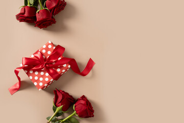 Valentine's day romantic gift and bouquet of red roses on beige background. Close up. Greeting card.