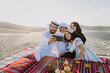© oneinchpunch - Happy family from Uae spending time in the Dubai desert making a picnic. Kid with the uae flag.
