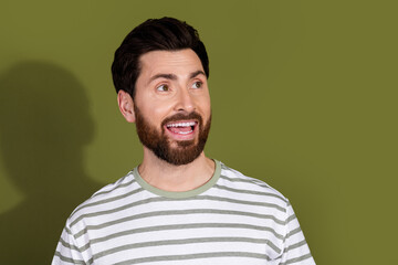 Wall Mural - Photo of cheerful positive man wear striped stylish clothes look empty space isolated on khaki color background