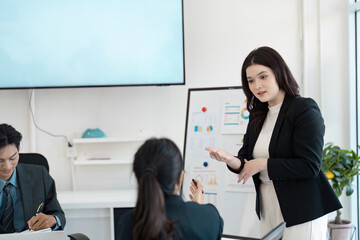 Wall Mural - diverse businesswoman leading a discussion on financial strategies in a modern office setting.