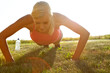 © peopleimages.com - Woman, fitness or push ups with grass field for workout, exercise or outdoor training in nature. Active, female person or lifting body weight with bottle for muscle gain, strength or healthy wellness