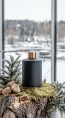 Wall Mural - A sleek and stylish black container is elegantly perched on a moss-covered log, set against a peaceful winter landscape blanketed in snow