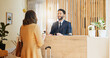 © peopleimages.com - Hotel, check in and woman at desk with man, smile and friendly reception service for hospitality. Welcome, registration and receptionist with client at counter for accommodation, booking and travel
