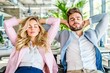 © Georgy - Calm and happy businessmen and businesswomen relax with their eyes closed, hands behind their heads, seated in ergonomic office chairs, smiling executives enjoy a break, lounging after work in a
