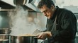 © arhendrix - A chef preparing risotto in a professional kitchen with a pot of simmering broth