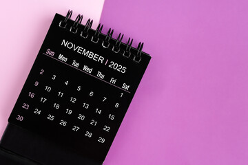 Wall Mural - November black desk calendar for 2025 year on purple background.