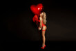 © marcink3333 - Sexy Valentine in red elegant lingerie sensually poses with big  heart shaped balloons on black background. Valentine's Day concept