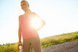© peopleimages.com - Break, runner and woman with smile, confident and happy for wellness with exercise, training or health. Outdoor, athlete and jogger with sportswear for workout, space or person in nature for practice