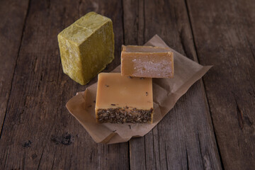 Bar soap of different colors on old wooden background