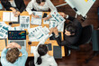 © InfiniteFlow - Wide top view of diverse group of business analyst team analyzing financial data report paper on meeting table. Chart and graph dashboard by business intelligence analysis. Meticulous
