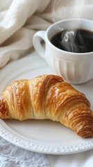 Wall Mural - Warm croissant served with steaming coffee on a cozy morning at home