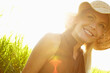 © peopleimages.com - Happy, farm and portrait of woman with sunhat for travel, vacation or getaway in countryside. Nature, flare and female person from Canada outdoor on field by grass for adventure, journey or holiday.