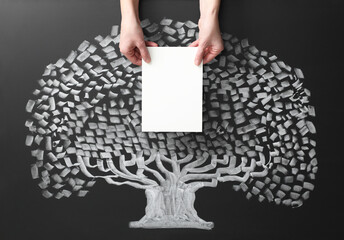 Wall Mural - Woman holding blank paper sheet over chalkboard with tree drawing, closeup