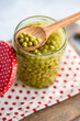 © ADDICTIVE STOCK - Green organic peas in glass jar with wooden spoon