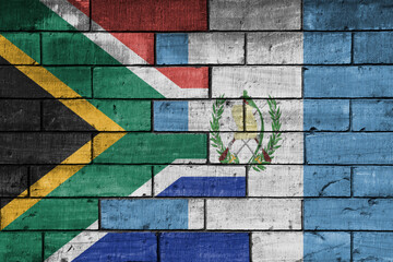 Wall Mural - colourful painted big flag of south africa and flag of guatemala on a massive old brick wall background. concept