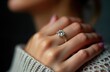 © Viktor - Close-up elegant engagement ring on woman finger. Sparkling diamond ring on soft hand. Dark background. Luxurious accessory. Celebration concept. Woman wears fashionable ring. Romantic moment