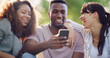 © peopleimages.com - Phone, happy and group of friends in nature browsing on social media for celebrity gossip. Laughing, cellphone and young people outdoor in park reading online blog for news, update or review together