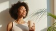 © VaVu  - Woman enjoying a relaxing moment with a healthy smoothie in sunlit room