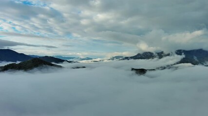 Wall Mural - flying between the clouds. aerial view of clouds and mountains at sunrise. traveling by air backgrou