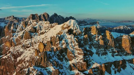 Wall Mural - aerial view of amazing rocky mountains in snow at sunrise, dolomites, italy, 4k
