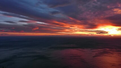 Wall Mural - aerial view of sea surface during a dramatic red sunset, panorama 4k