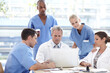 © peopleimages.com - Laptop, medical and group in discussion for healthcare training, planning and mentor help interns. People, doctor and team of nurses in meeting for cooperation or brainstorming results in hospital