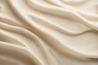 © piyawat - Smooth beige fabric with flowing folds, topdown view.