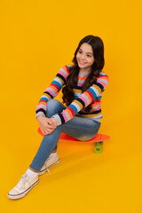 Wall Mural - Fashion teenage lifestyle, beautiful teen girl with skateboard isolated on studio background. Happy teenager, positive and smiling emotions of teen girl.