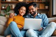 © SimpleDesignStudio - A Happy Couple Enjoying Quality Time Together While Using a Laptop on a Cozy Couch at Home in a Bright and Inviting Living Room Space