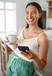 © peopleimages.com - Woman, coffee and portrait with phone in home for caffeine break, start day and reading morning news. Girl, happy and app with beverage for relax, browsing online and social media scroll in kitchen