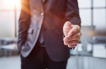 Wall Mural - Businessman manager stretching out hand for handshake to partner in office closeup. Team work concept