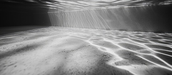 Aufkleber - Underwater landscape with light rays and patterns on the sand in black and white Copy Space