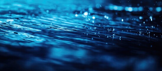 Leinwandbilder - Blue water surface with ripples and rain droplets creating a dynamic, textured background suitable for various design purposes Copy Space