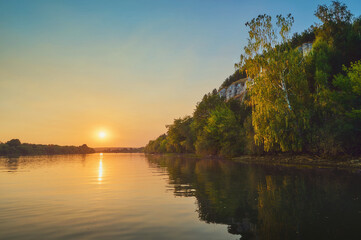 Wall Mural - a beautiful evening scene on the river, with the sun reflecting beautifully in the water.