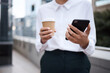 © peopleimages.com - Hands, coffee or businesswoman in city with phone or online connection for text message or social media chat. Lawyer, balcony or legal advisor typing on mobile app for news, schedule or notification