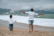 © alexkoral - back of happy father dad with a child son are walking along the beach by the sea on a summer vacation
