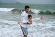© alexkoral - happy father dad with child boy son playing on the beach by the sea in summer on vacation