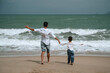 © alexkoral - back of happy father dad with child boy son running along the beach by the sea in summer on vacation